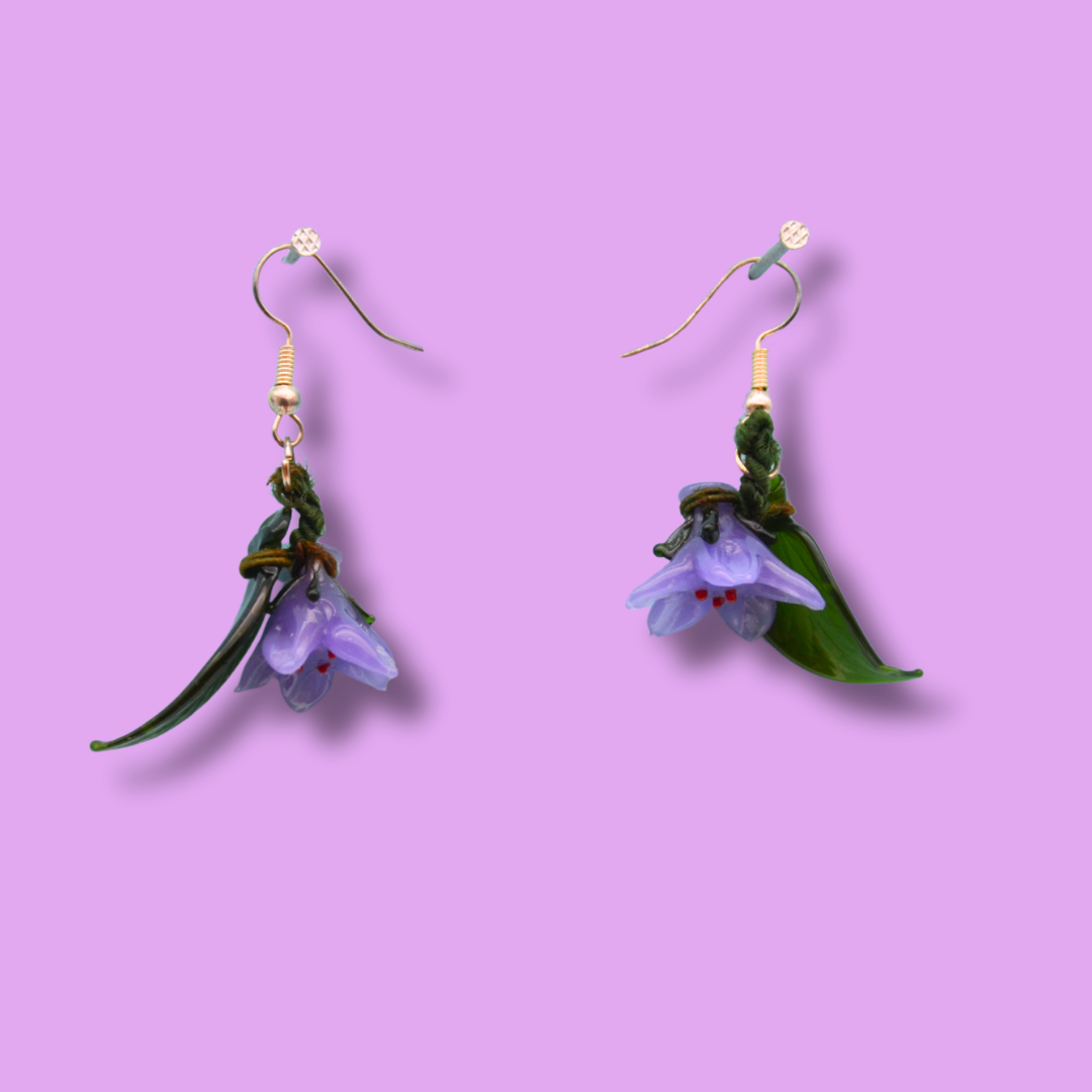 Örhängen lila blommor i glas
